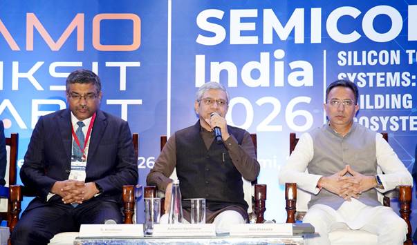 Sprekers tijdens SEMICON India 2026 in New Delhi; de middelste spreker houdt een microfoon vast.
